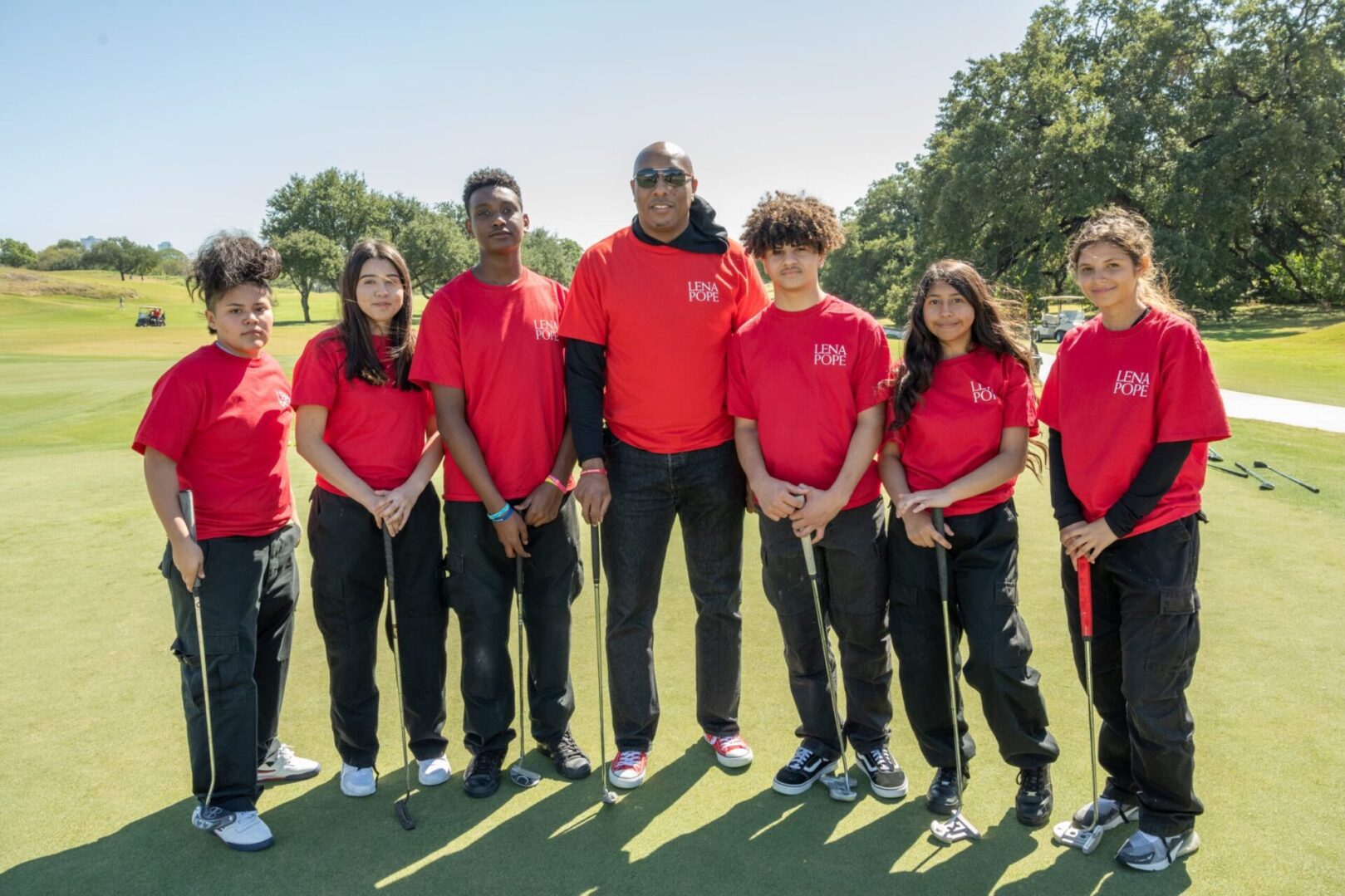 A group of people standing on top of a golf course.