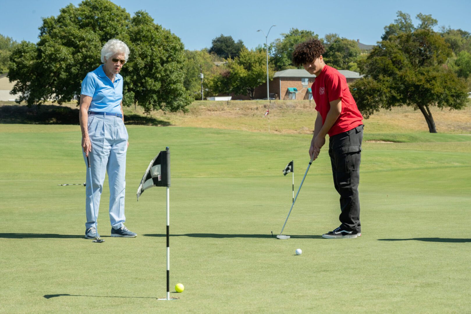 A man and woman playing golf on the green.