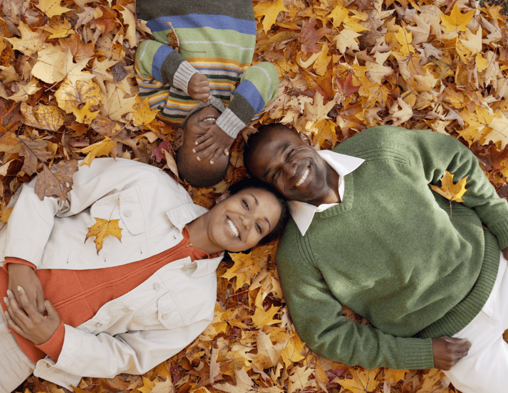 A man and two women laying in the leaves
