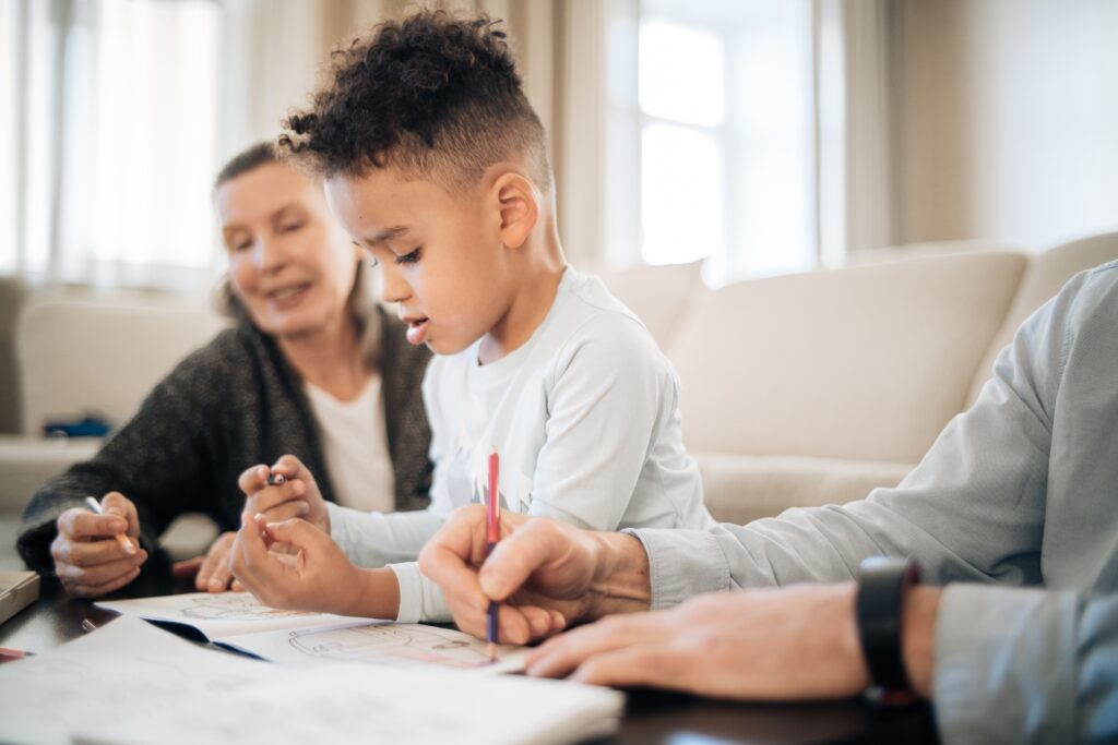 A young boy sitting at the table with his parents.