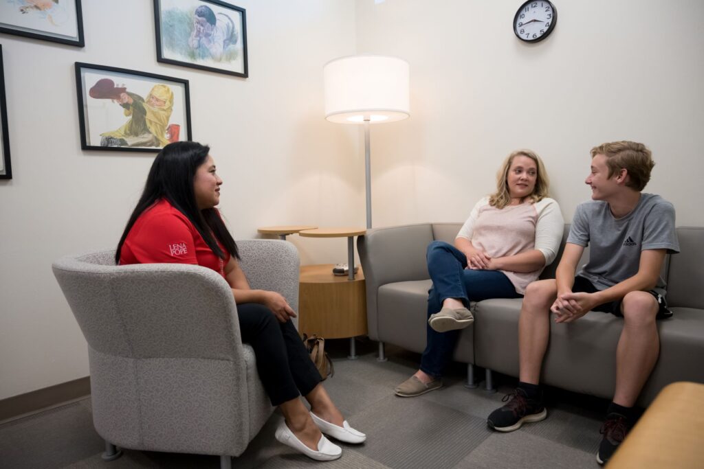 A group of people sitting in chairs talking.