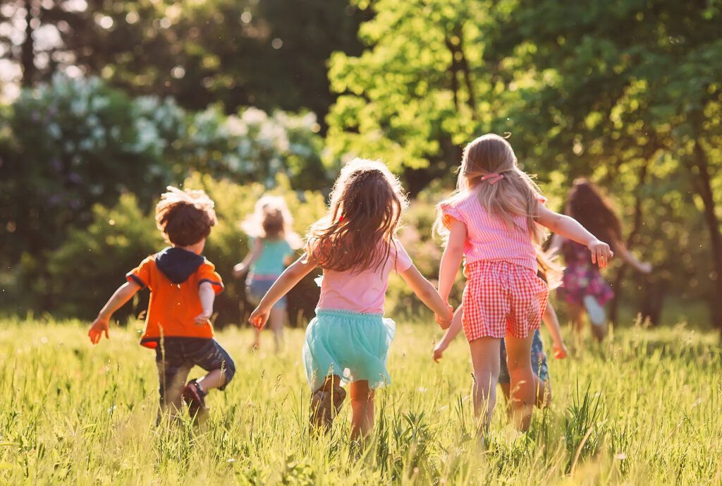 A group of children running through the grass.