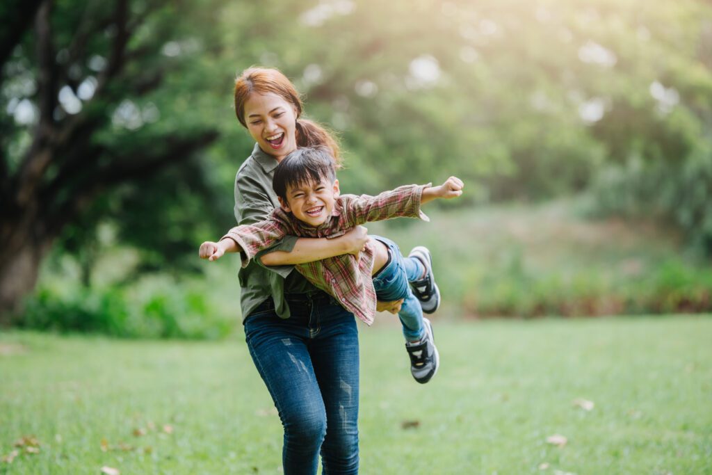 A woman and child are playing in the grass.
