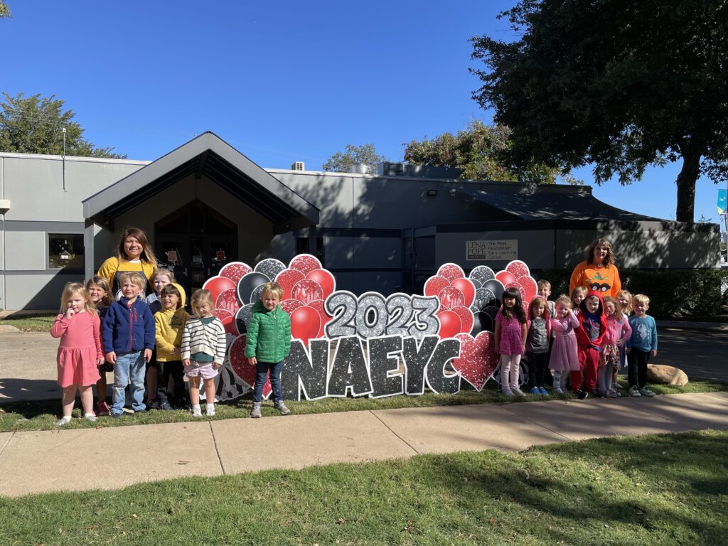 A group of children standing in front of a building.