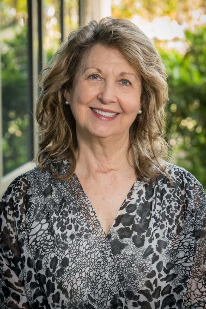 A woman with long hair and a leopard print blouse.