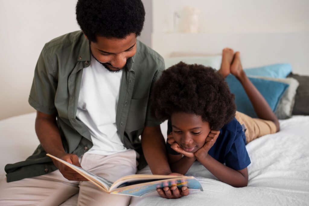 A man and boy reading a book on the bed