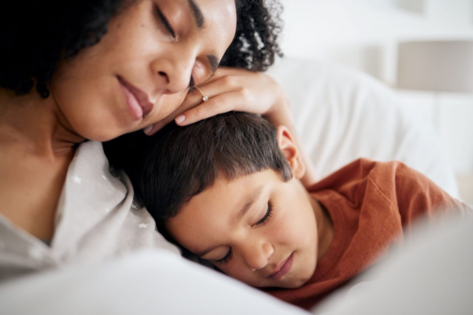 A woman and child sleeping in bed.