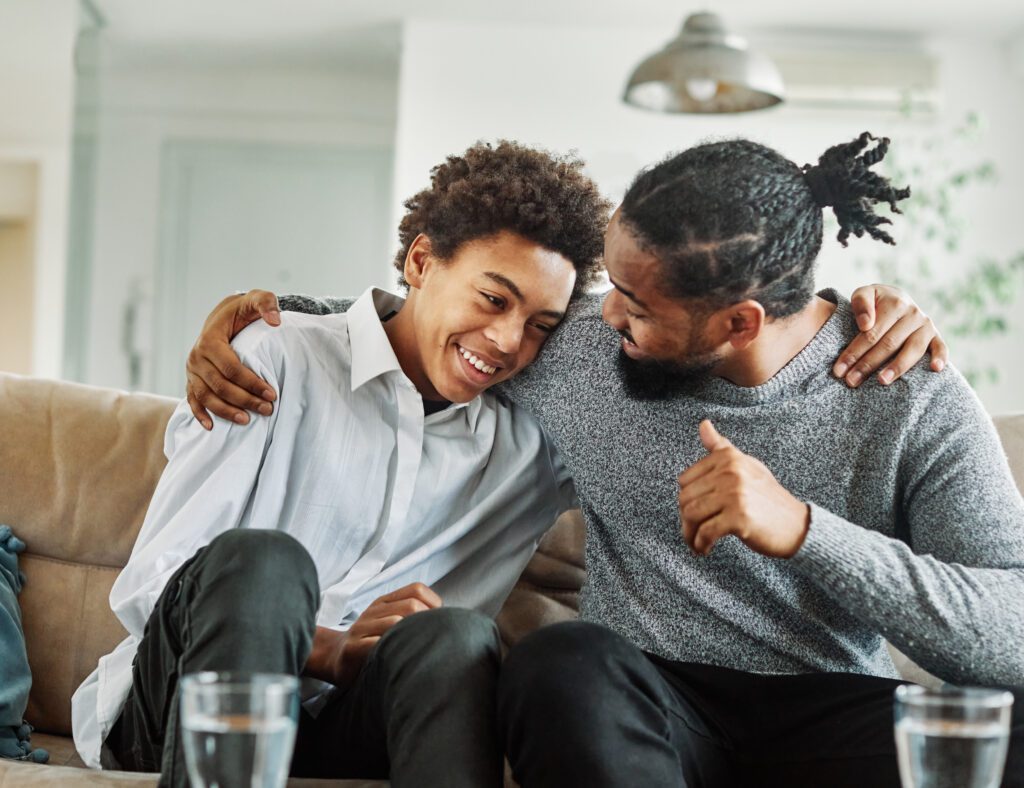 A man and boy sitting on the couch together.