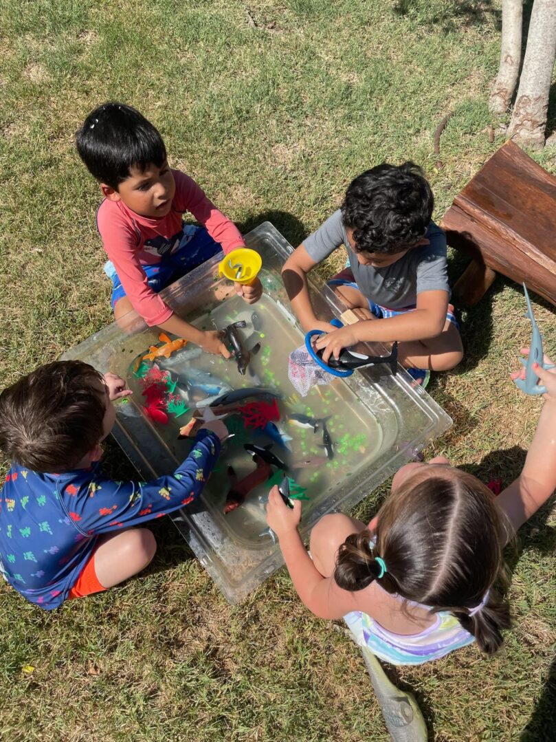 A group of children sitting around in the grass.