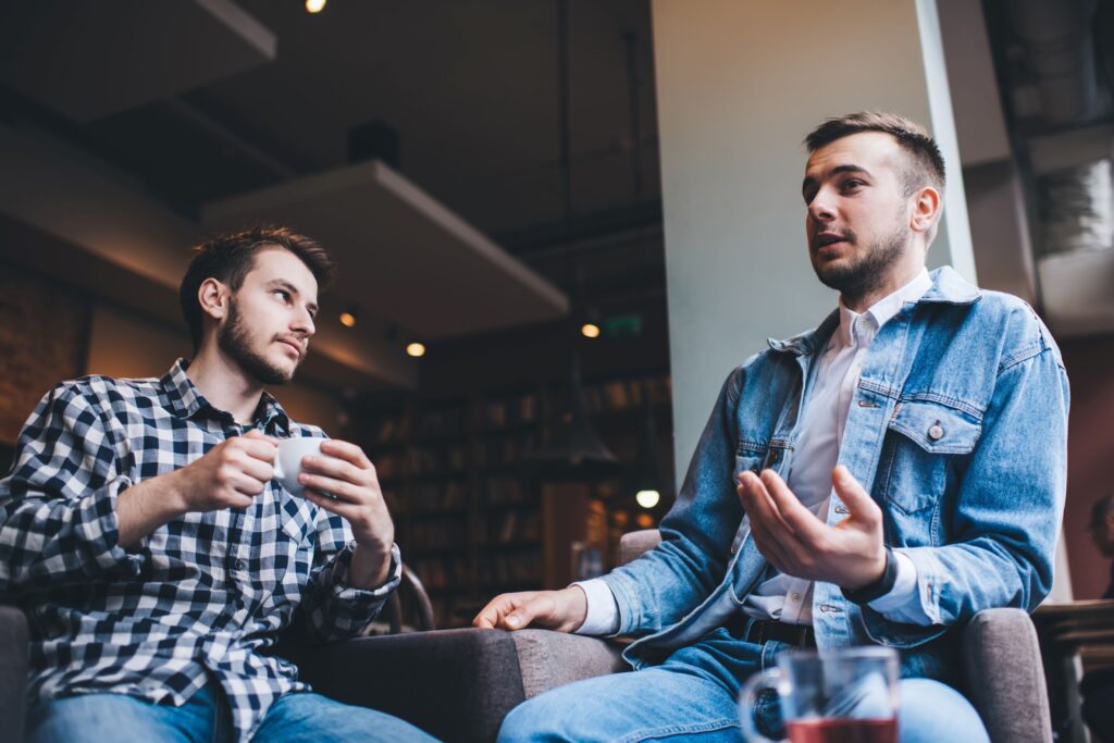 Two young men sitting and talking together