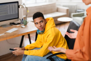 Teen in yellow hoodie holding smartphone