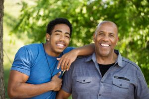 Smiling father and son embracing outdoors