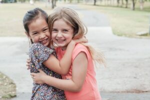 elementary age girls hugging, friendship